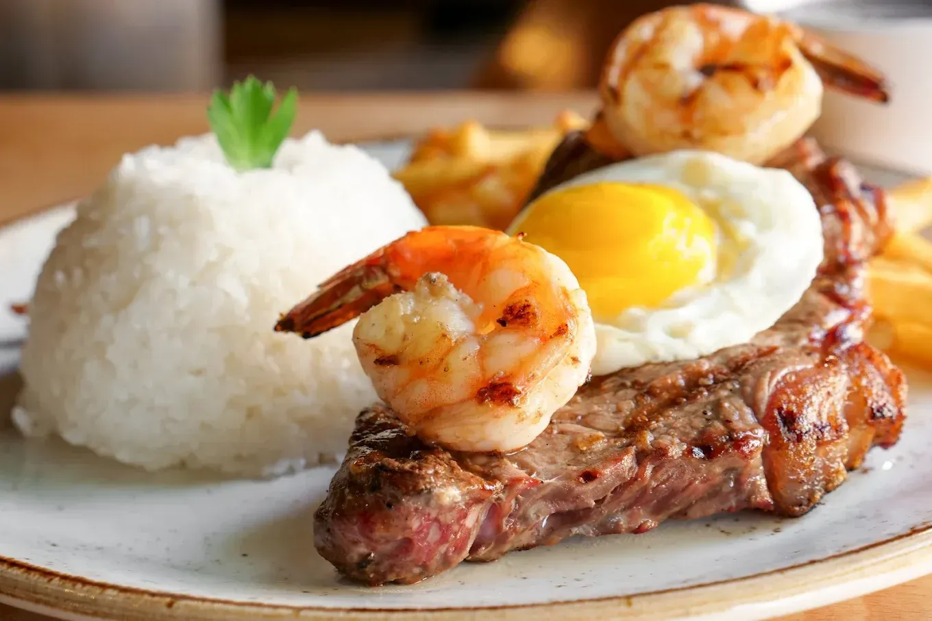 The best Brazilian food in Toronto, rice, steak, and grilled shrimp served on a plate at Rio 40 restaurant.
