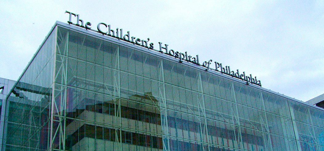 The Children's Hospital of Philadelphia building with glass facade against a cloudy sky.