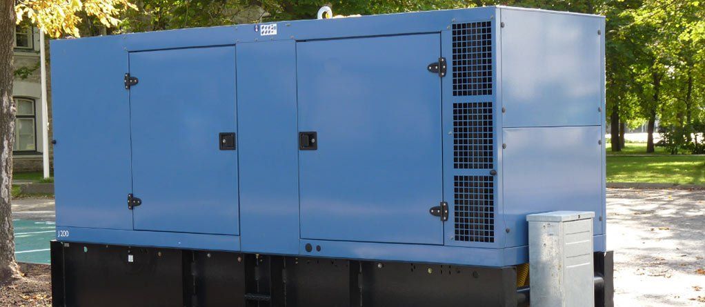 Blue generator enclosure outdoors on a platform; trees in background.