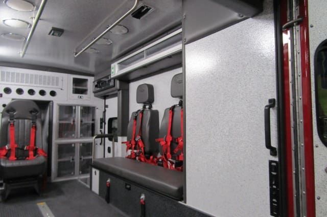 The inside of an ambulance with red seat belts