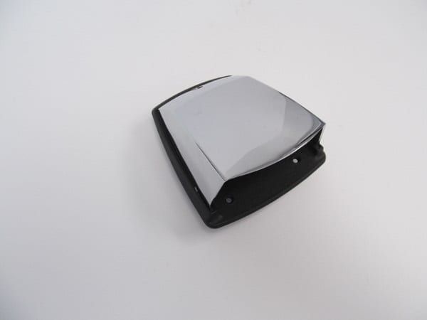 A black and chrome object is sitting on a white surface