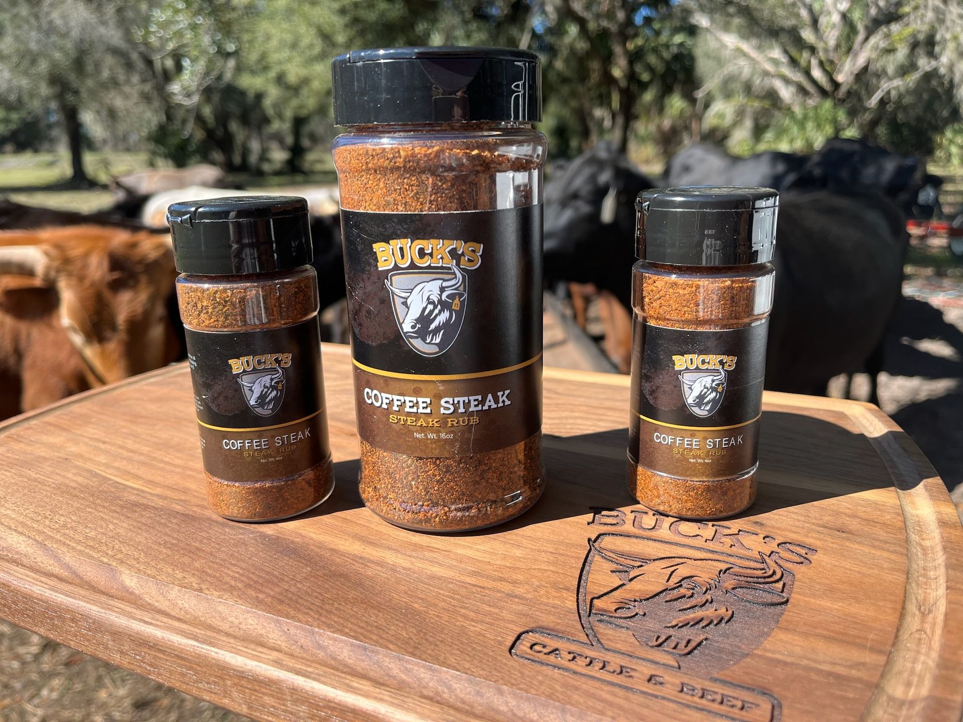 Three spice jars on a wooden board outdoors, with a dog in the background.