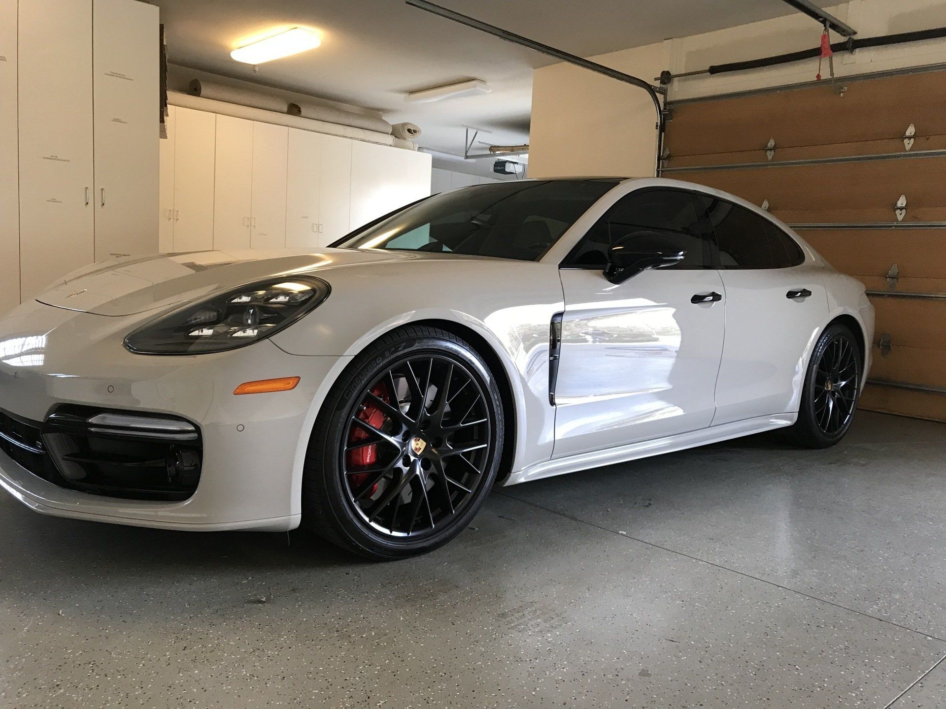 a white porsche panamera parked in a garage .