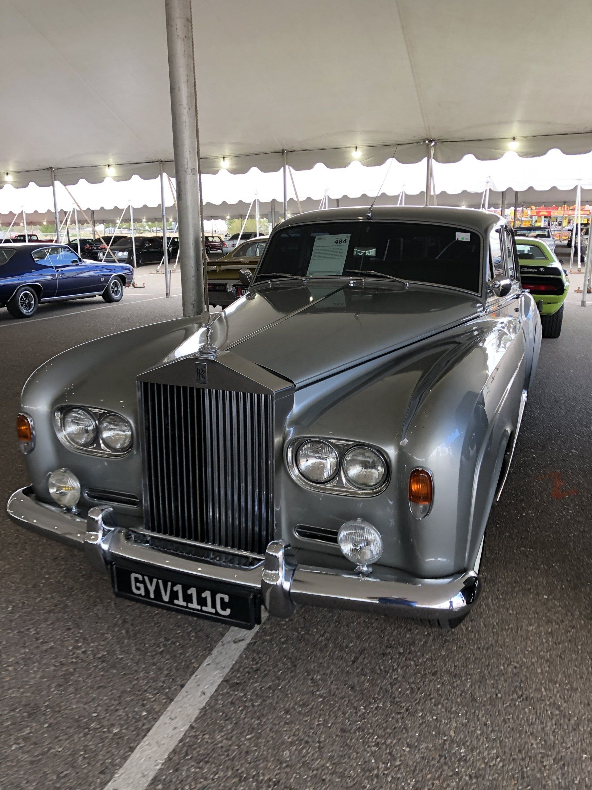 a silver rolls royce parked under a tent