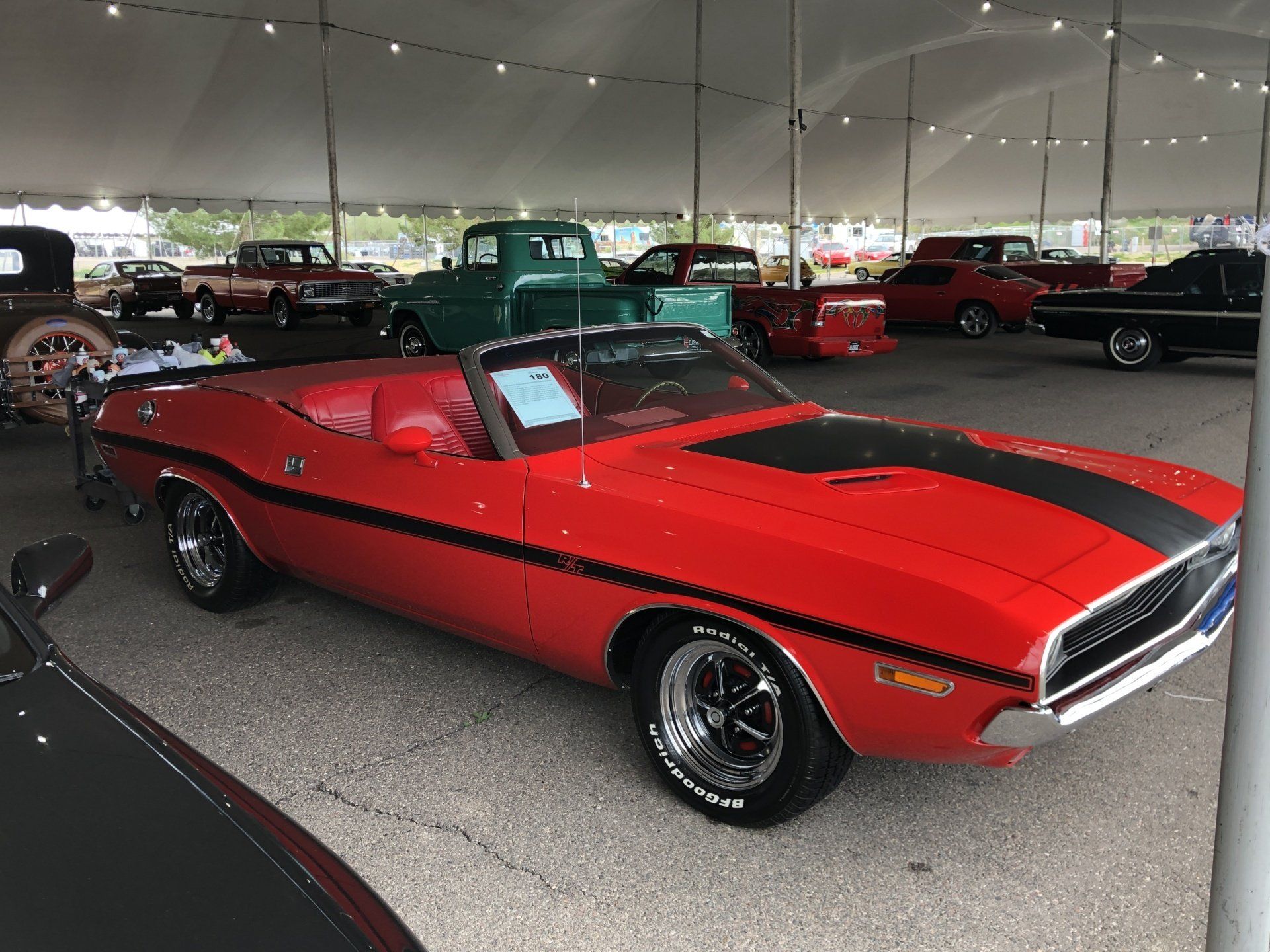 a red convertible car parked under a tent .