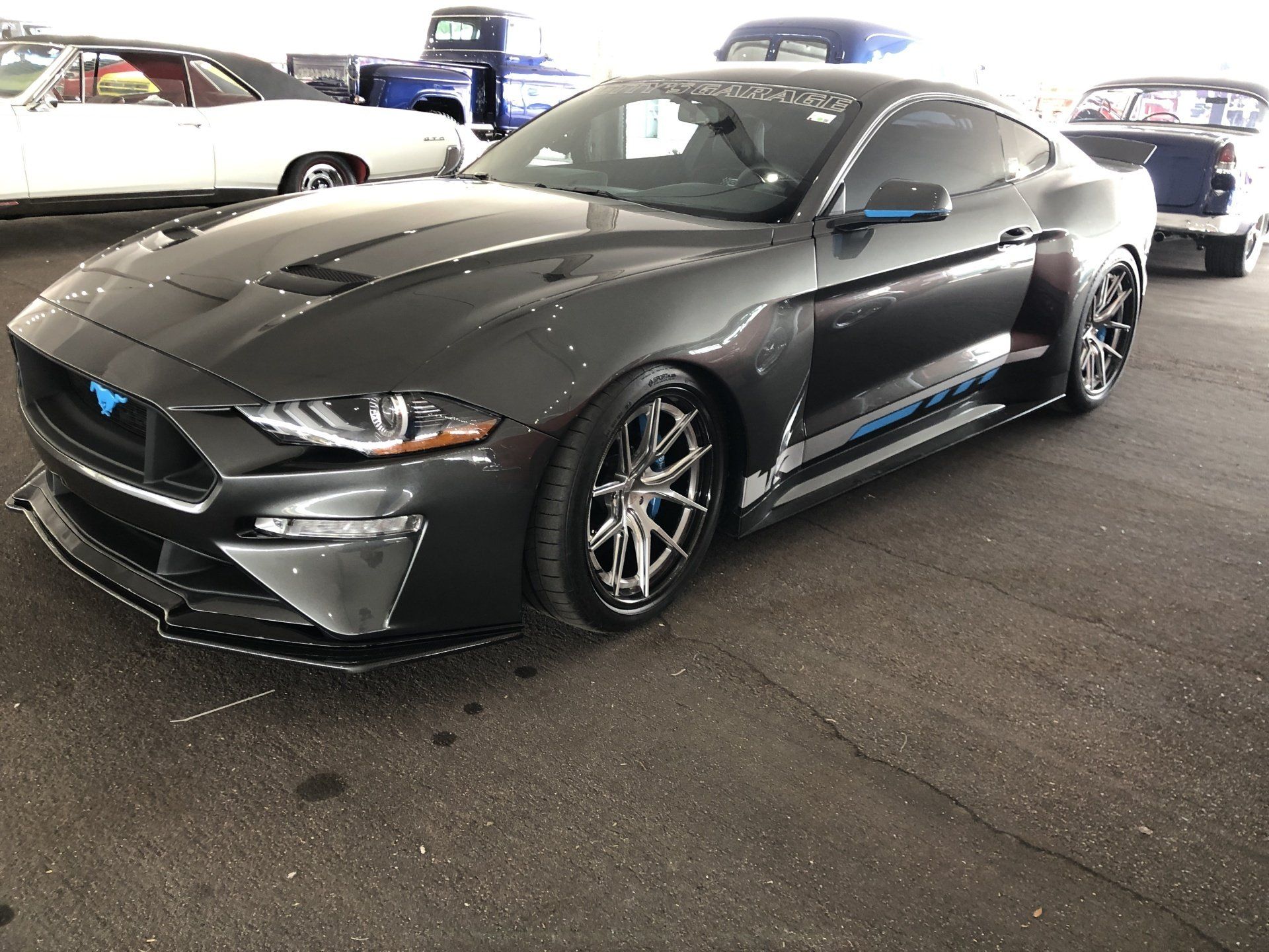a black ford mustang parked in a parking lot .
