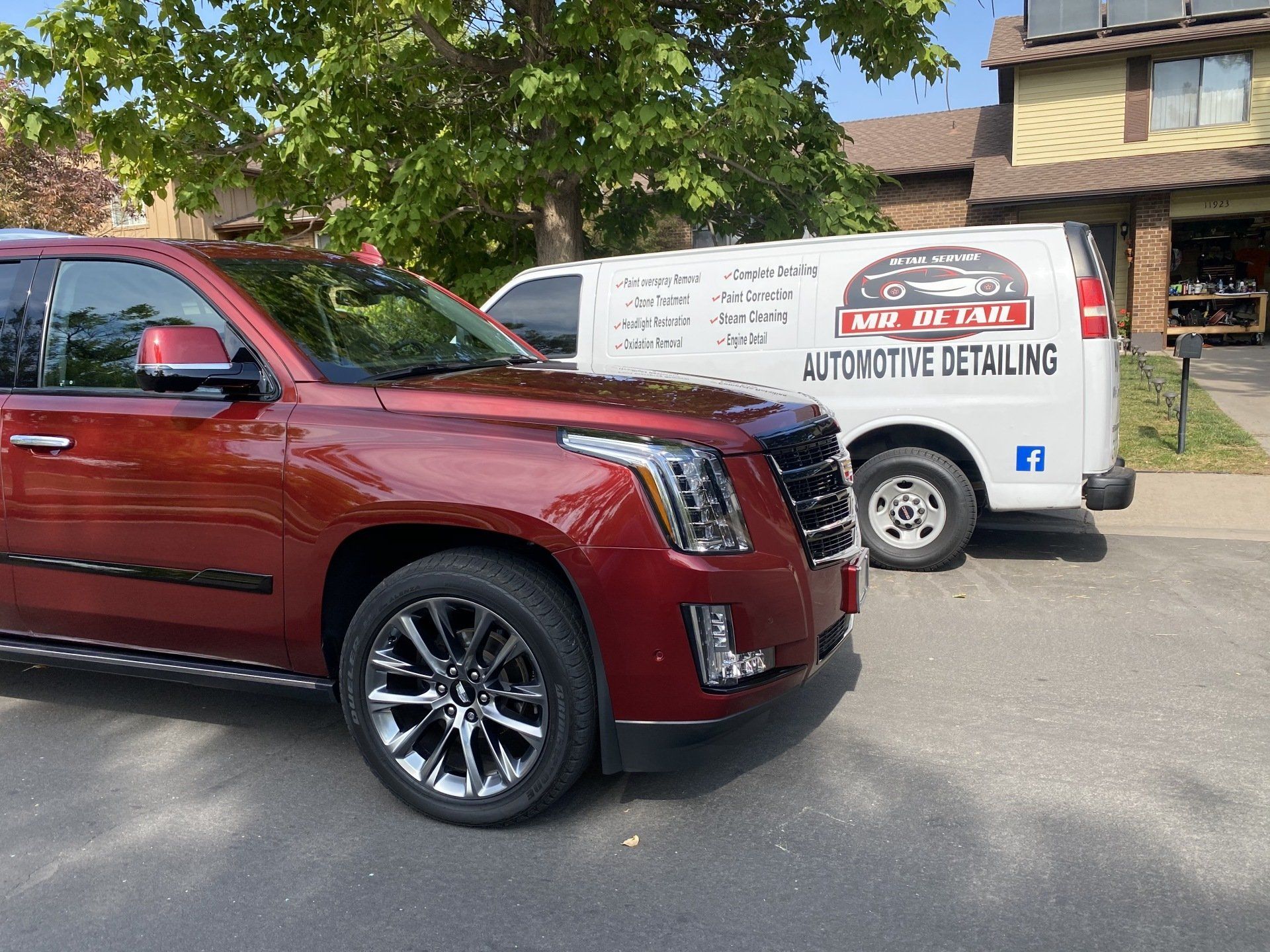 a red truck parked next to a white van that says automotive detailing