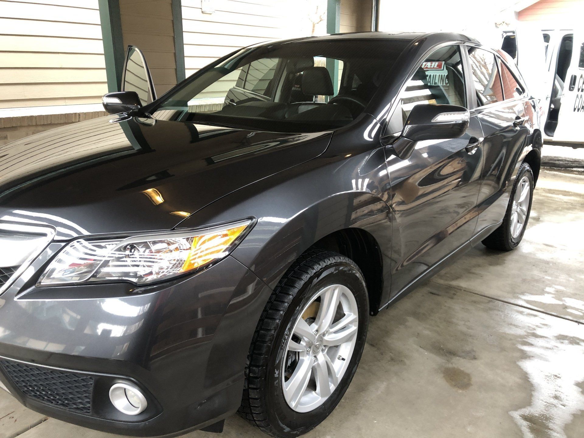 a black car parked in a driveway next to a house .
