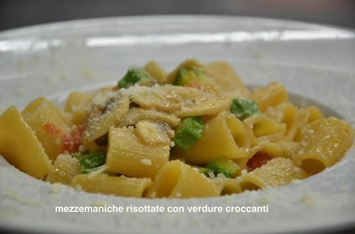 Un primo piano di un piatto di pasta con piselli e funghi