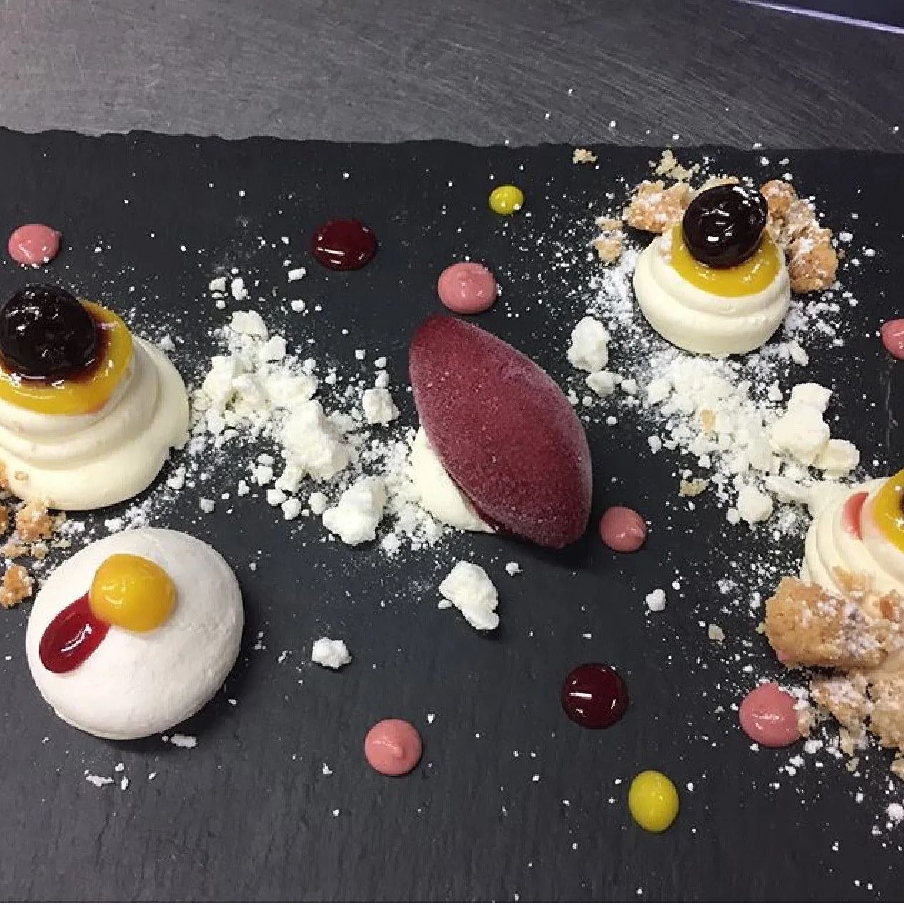 Un piatto nero con una varietà di dessert sopra