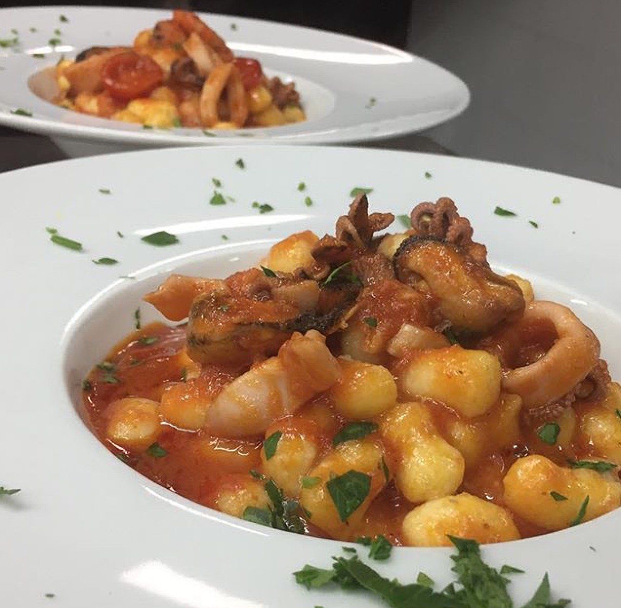 Due ciotole di cibo con gnocchi e salsa su un tavolo