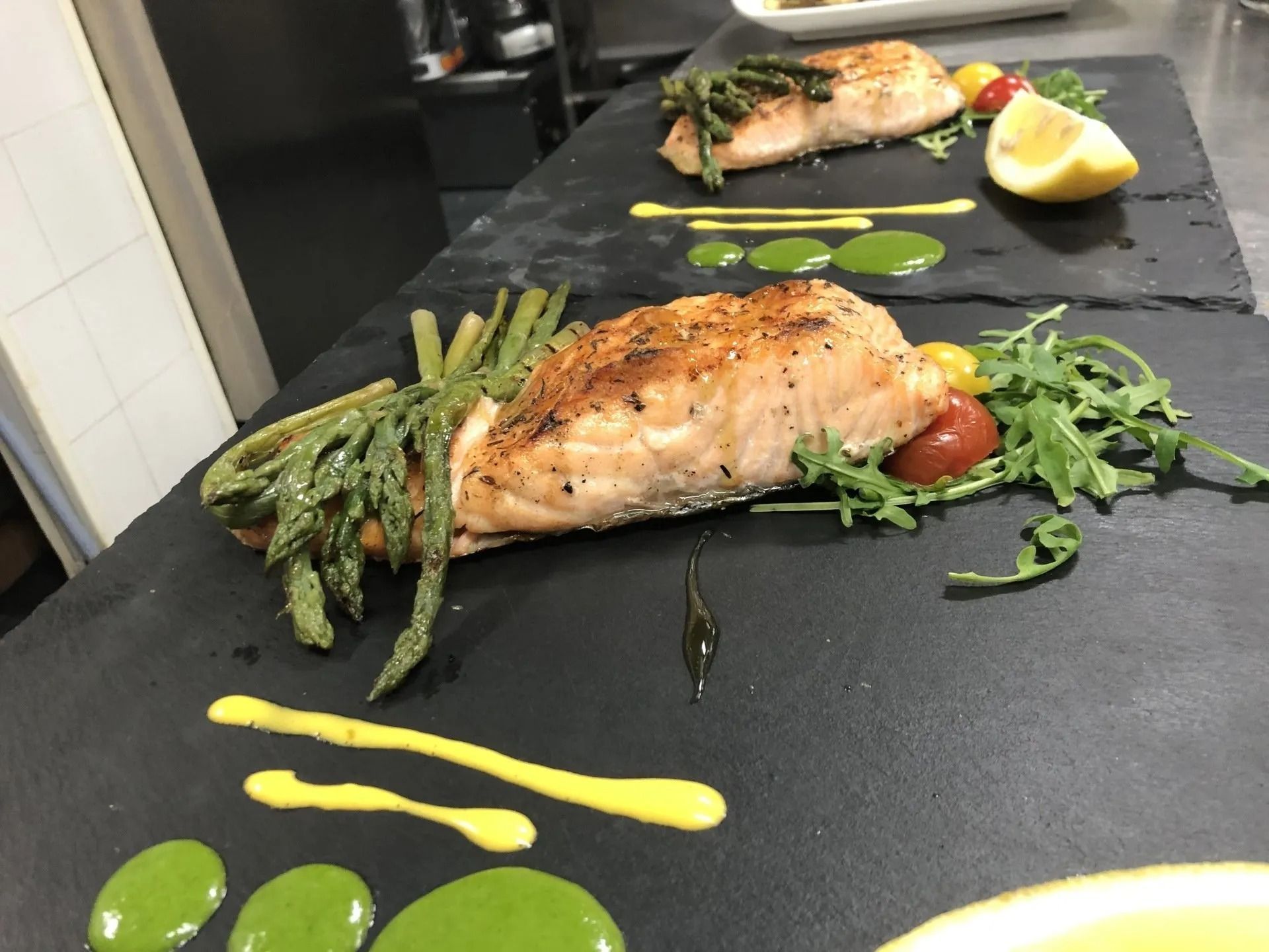 Un piatto di cibo con sopra asparagi e salmone