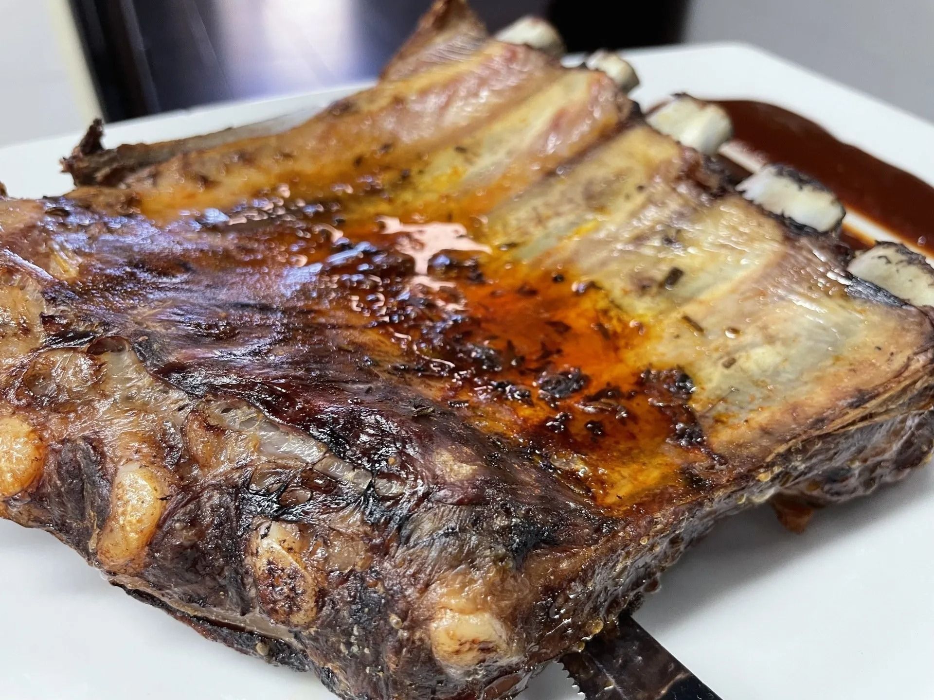 Primo piano di un pezzo di carne su un piatto con salsa.