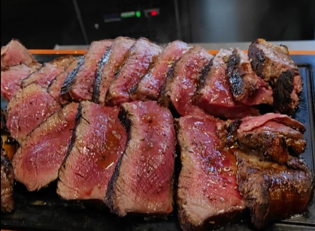 Un grosso pezzo di bistecca è appoggiato su un tagliere.