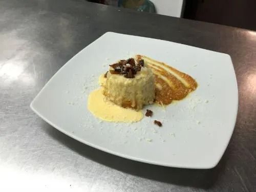 Un piatto bianco con un dessert sopra su un tavolo.