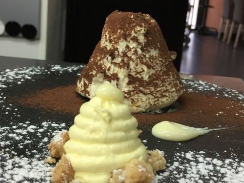 Un primo piano di un dessert su un piatto con zucchero a velo