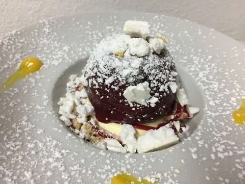 Un primo piano di un dessert su un piatto con zucchero a velo sopra.