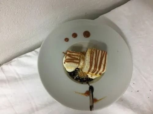 Un piatto bianco con un dessert sopra su un tavolo.