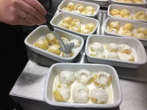 Una persona prende il cibo da una ciotola con un cucchiaio.