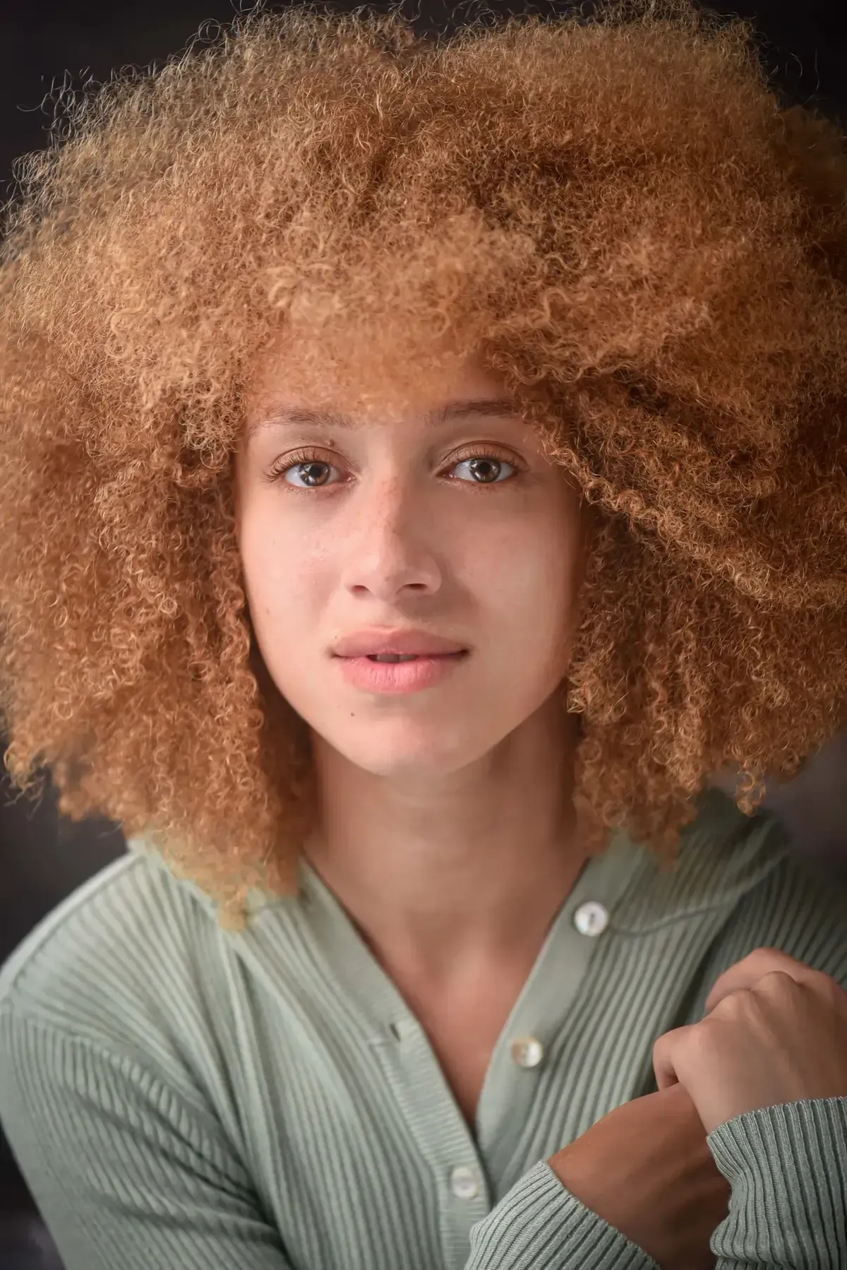 Silhouette of a person with a large, textured Afro against a white background.