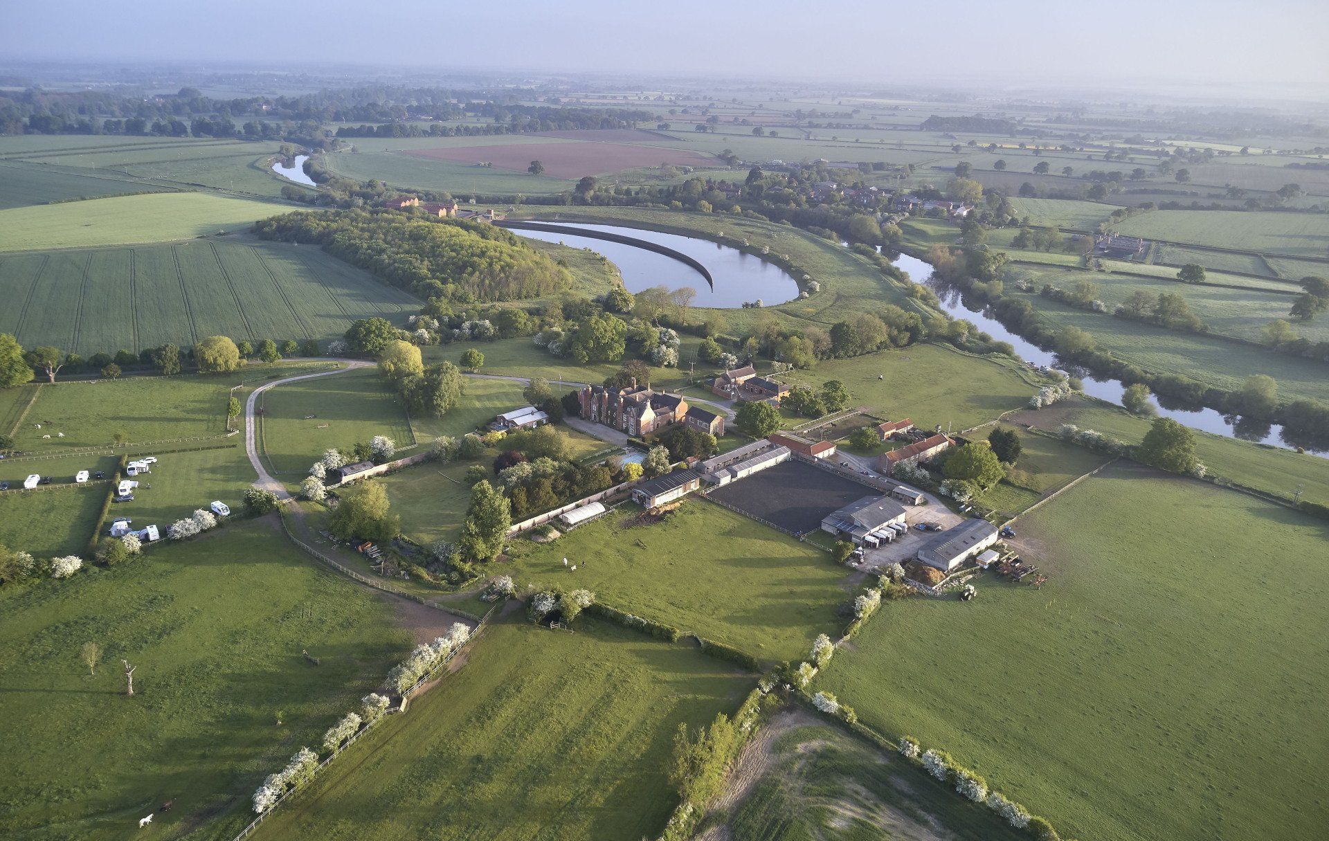 An aerial view of a farm with a river running through it