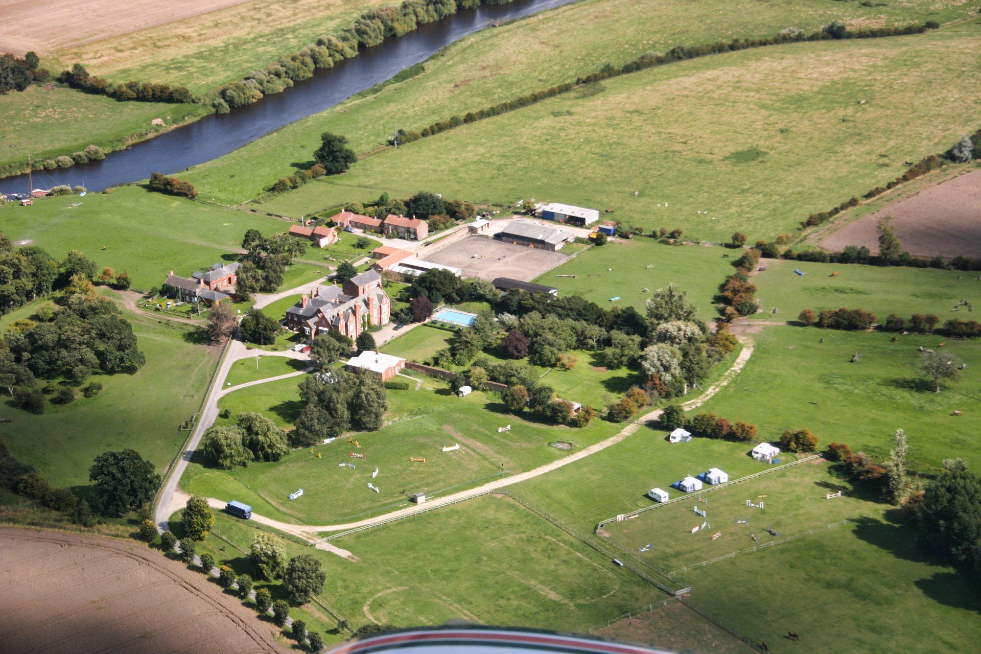 An aerial view of a farm with a river running through it