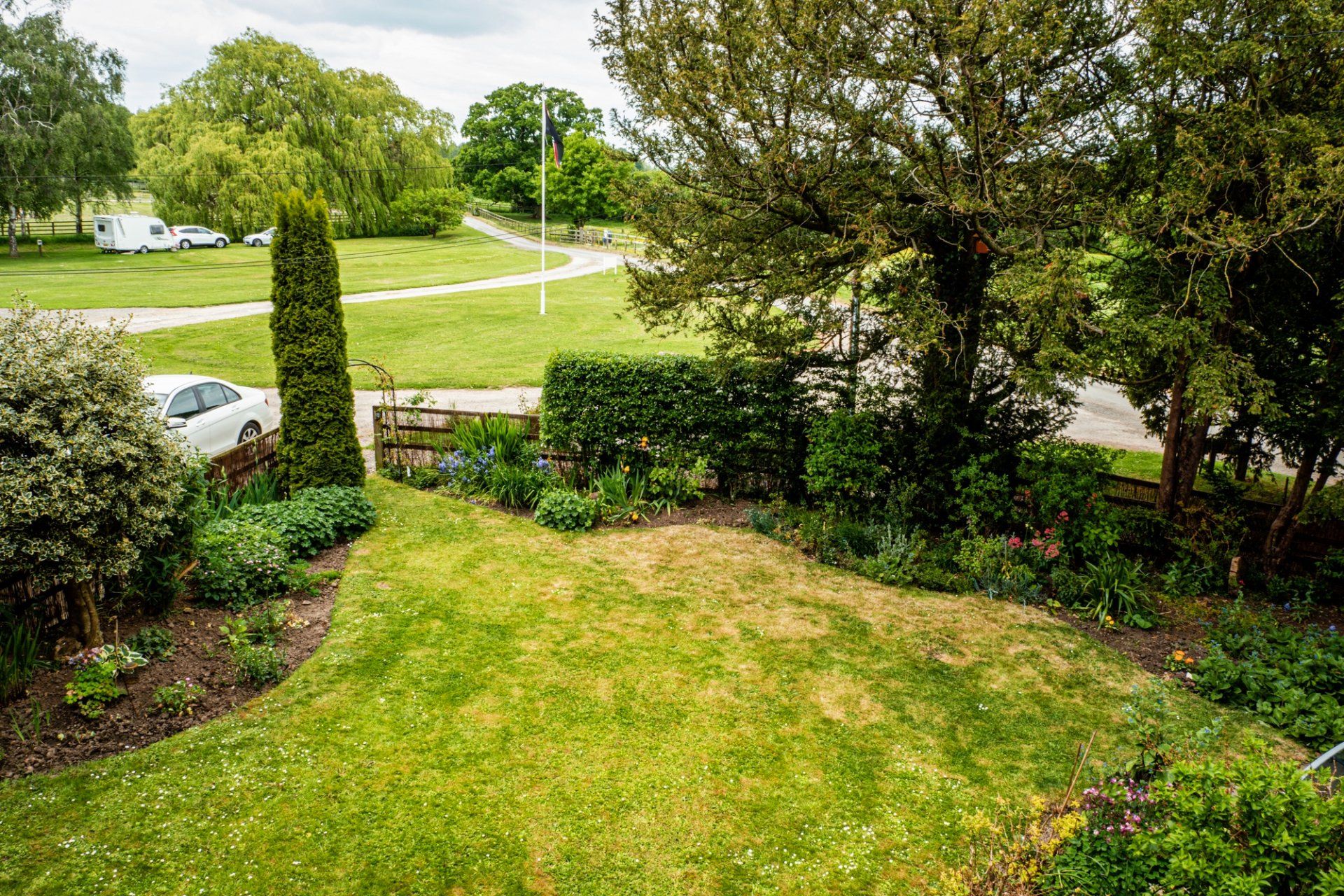 An aerial view of a lush green lawn surrounded by trees and bushes.