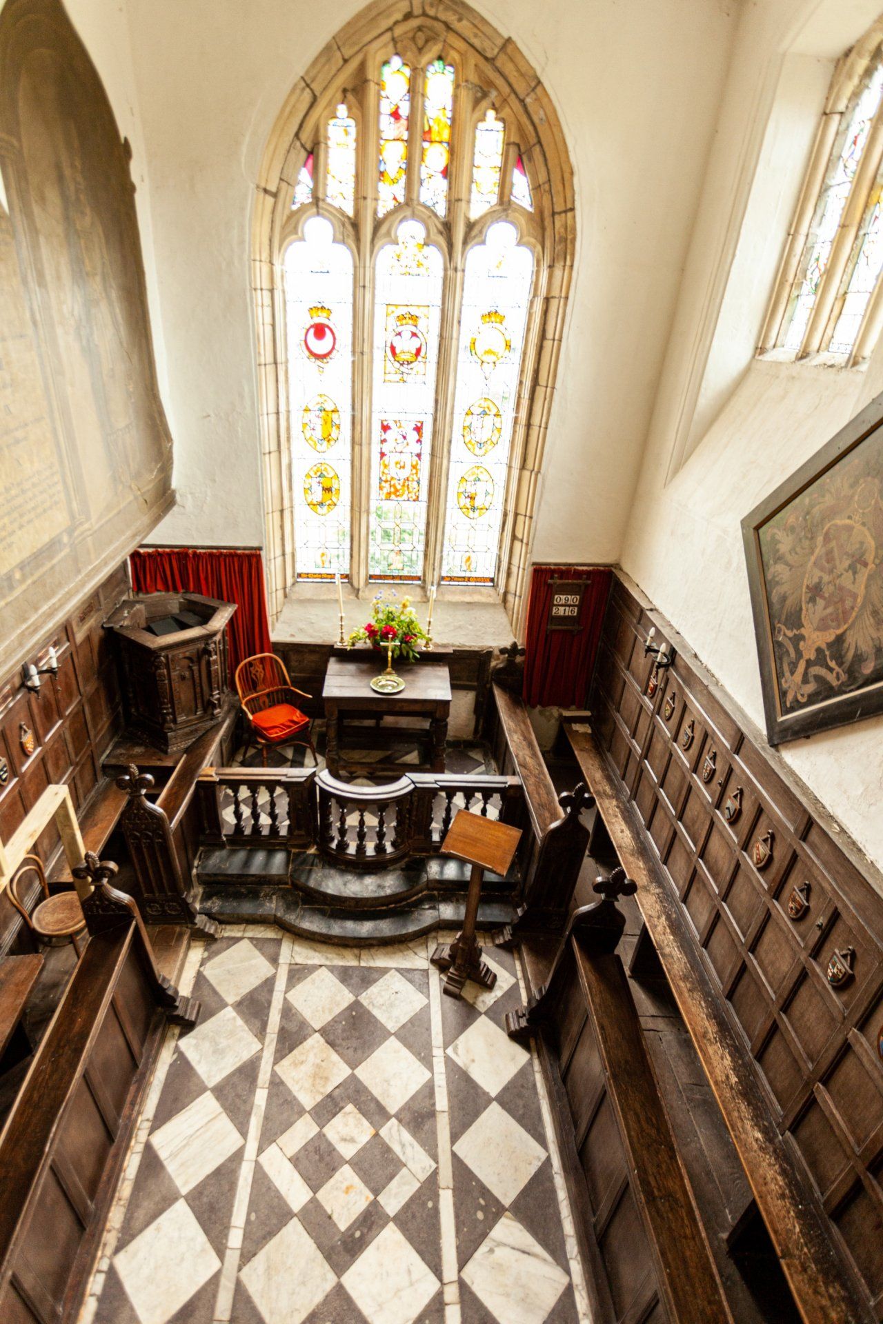 An aerial view of a church with a stained glass window and a checkered floor.