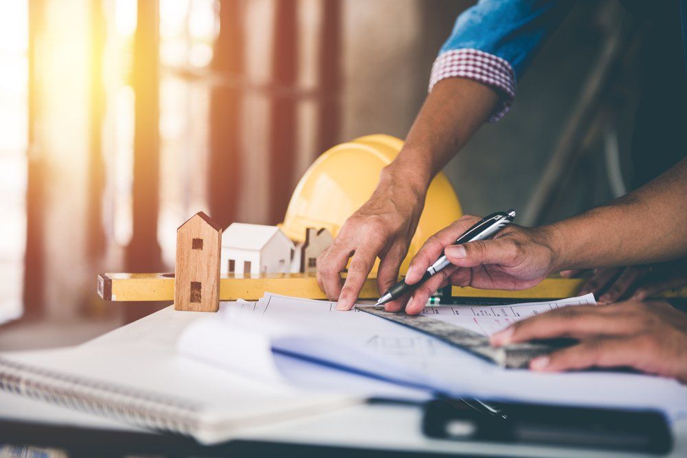 Architect Man Working With Blueprints — Builder In Albury–Wodonga, NSW