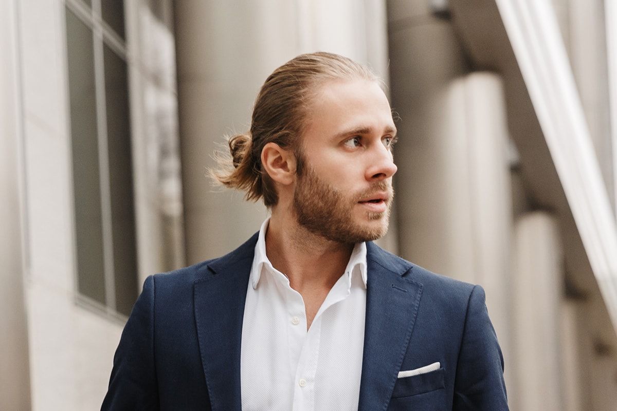 A man in a suit and white shirt is walking down the street.