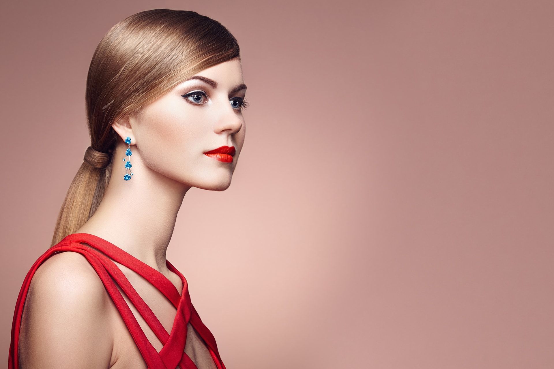 The woman is wearing a red dress and earrings.