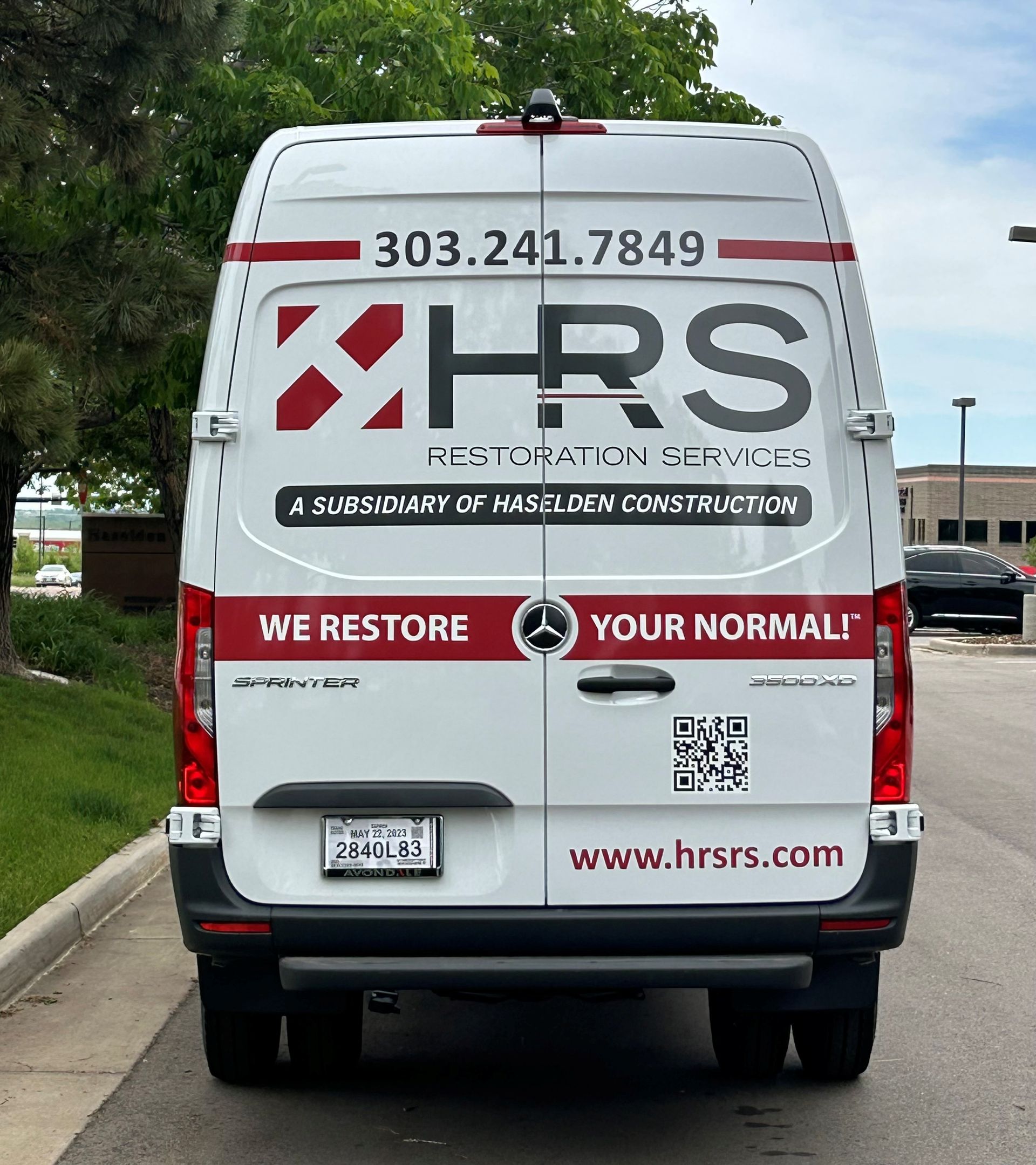 White HRS restoration service van with red and black logo and phone number.