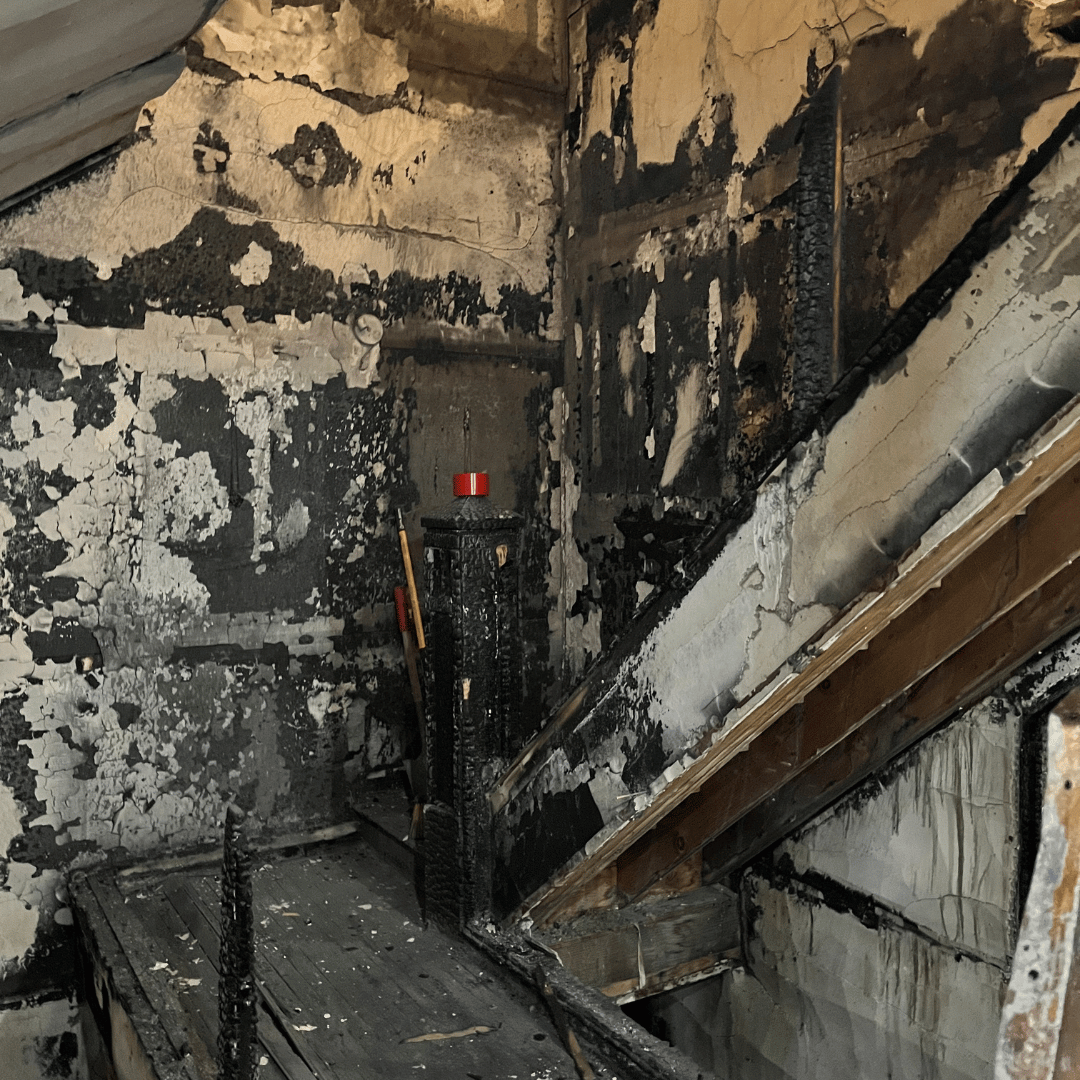 Charred interior of a building, with visible fire damage on walls and wooden beams - HRS Restoration Services in Colorado Springs, CO.