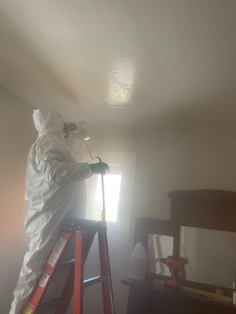 Mold remediation technician spraying ceiling by HRS Restoration Services in Denver Colorado