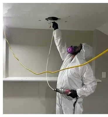 HRS Restoration Services technician repairing water-damaged ceiling in Denver Colorado