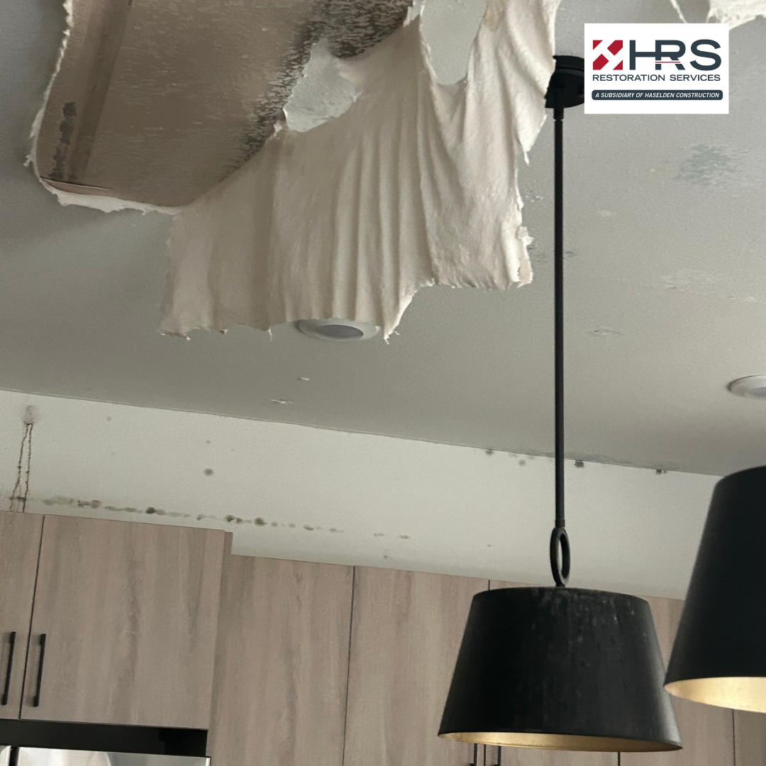 Kitchen ceiling with water damage, torn drywall, and visible moisture staining