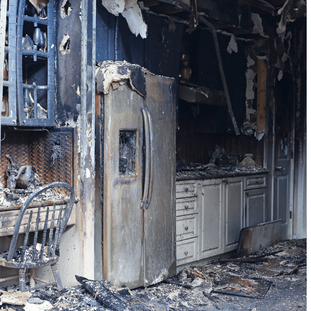 Burnt refrigerator and kitchen cabinets after fire damage in Denver, showing need for professional restoration by HRS.