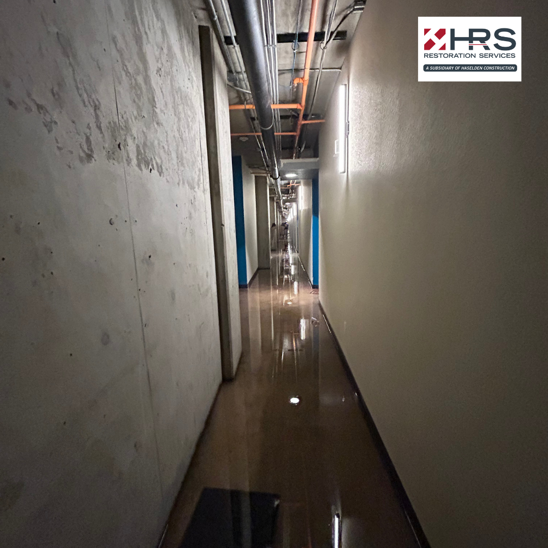 Flooded corridor with standing water during an active water damage event