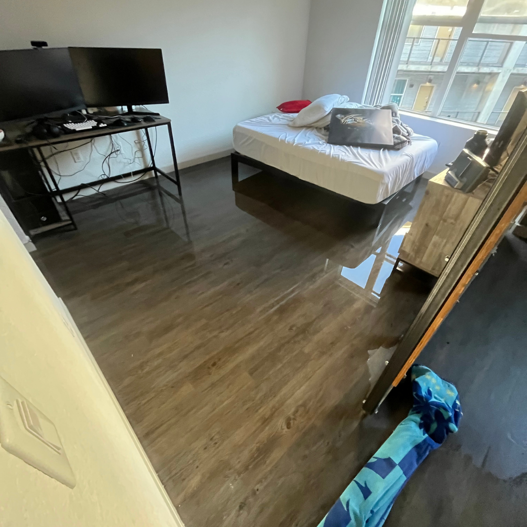 Standing water flooding a bedroom in Denver property requiring emergency water removal and extraction services