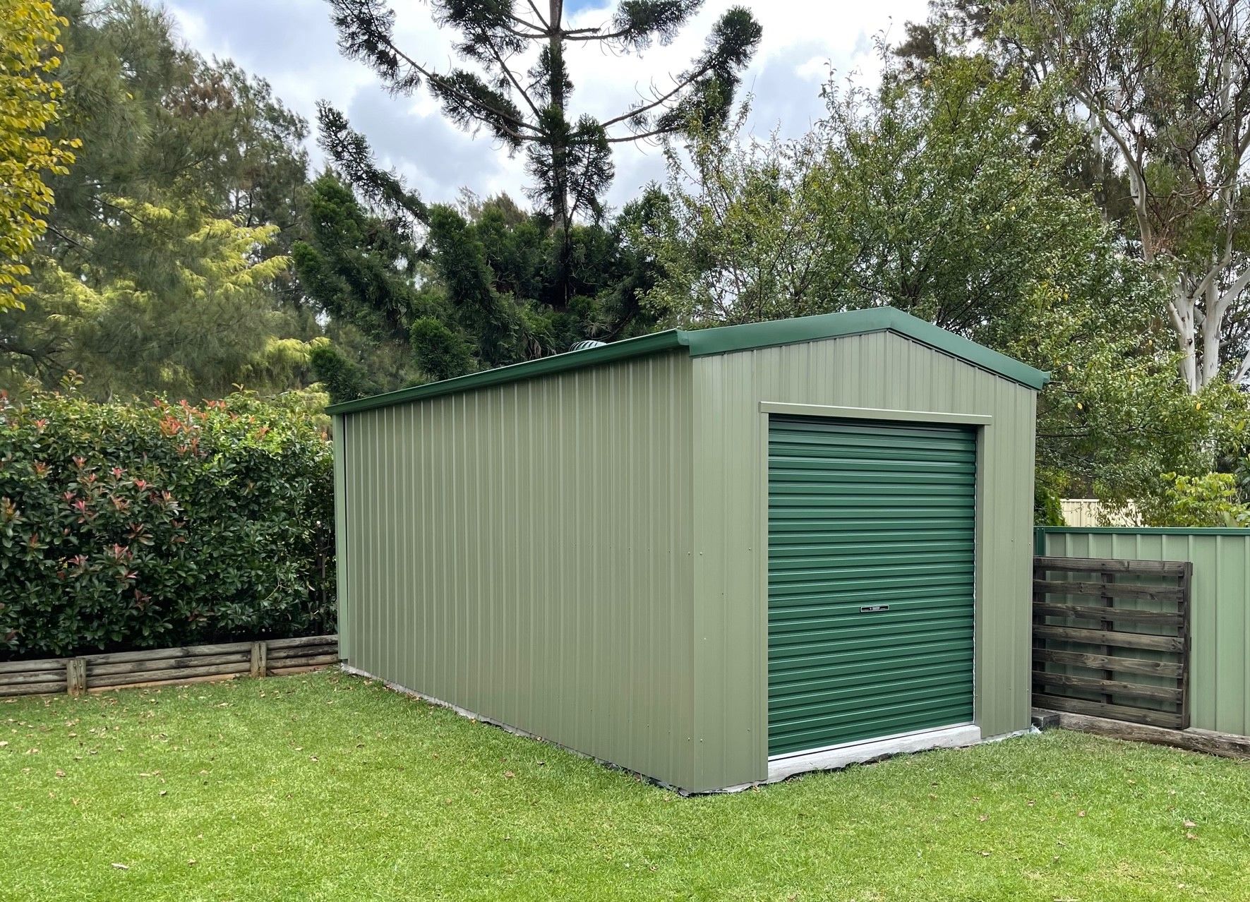 Light Green Single Garage With Dark Green Roller Door — ShedPro Constructions in Gloucester, NSW