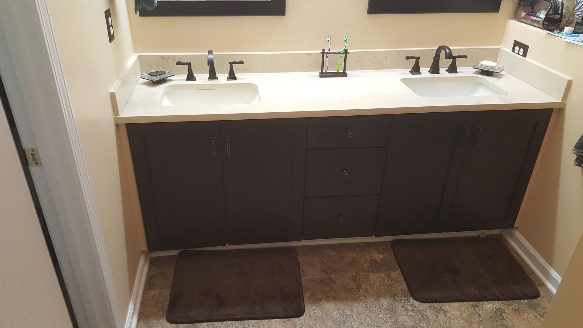 a bathroom vanity with two sinks and a toothbrush holder