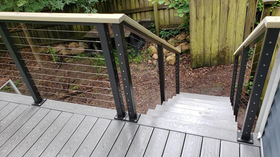 a deck with stairs leading up to a wooden fence