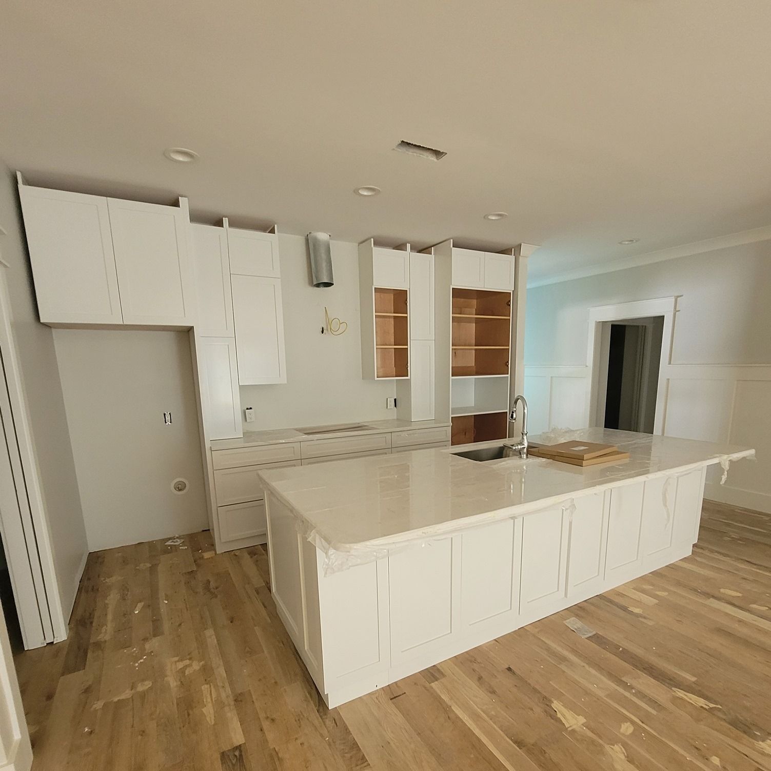 a kitchen with white cabinets and a large island