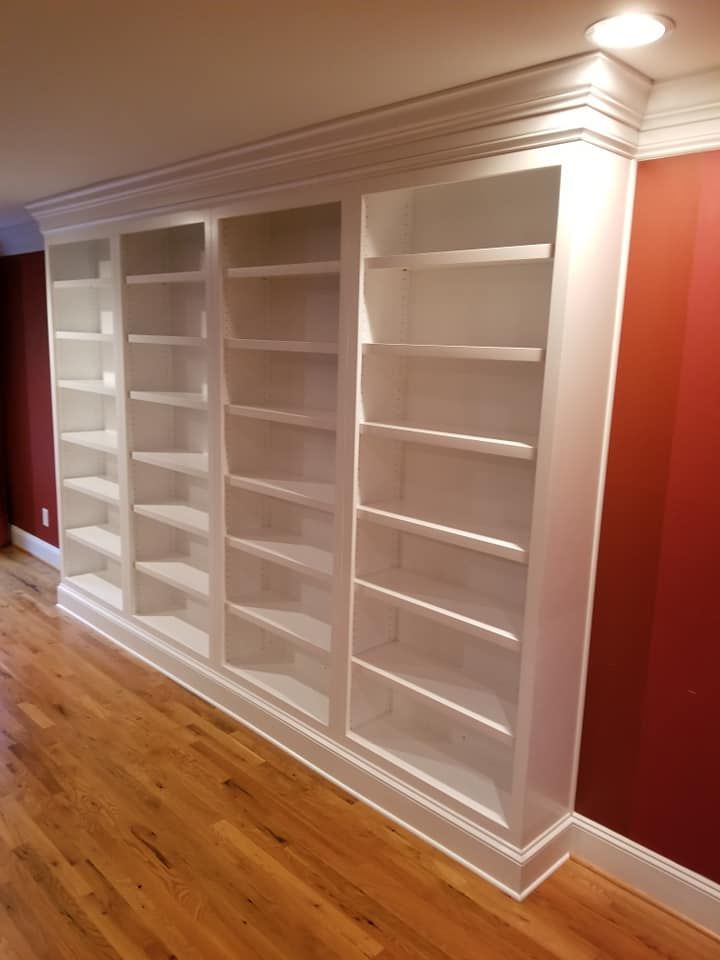 a row of white shelves in a room with red walls
