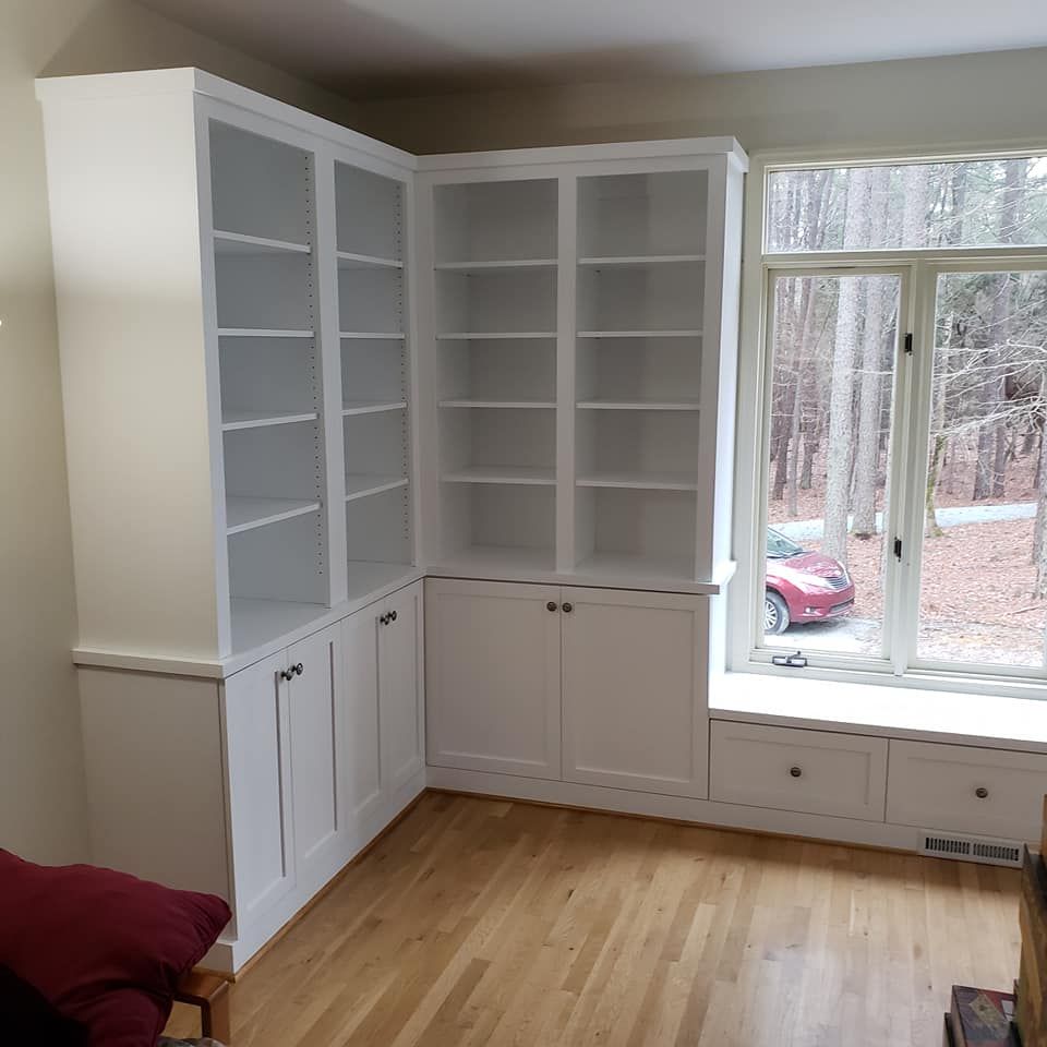 a living room with white shelves and a window seat