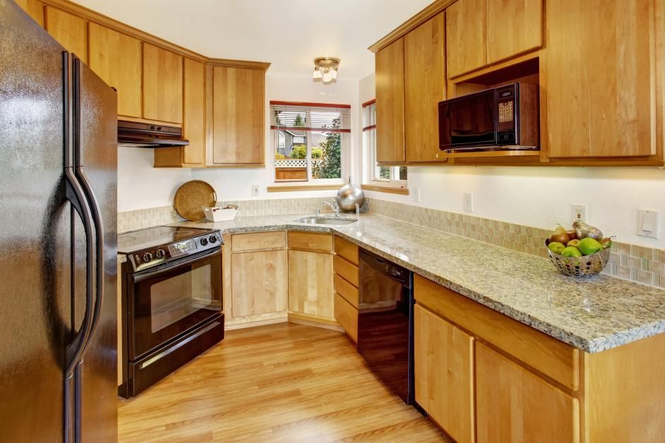 a kitchen with wooden cabinets and granite counter tops