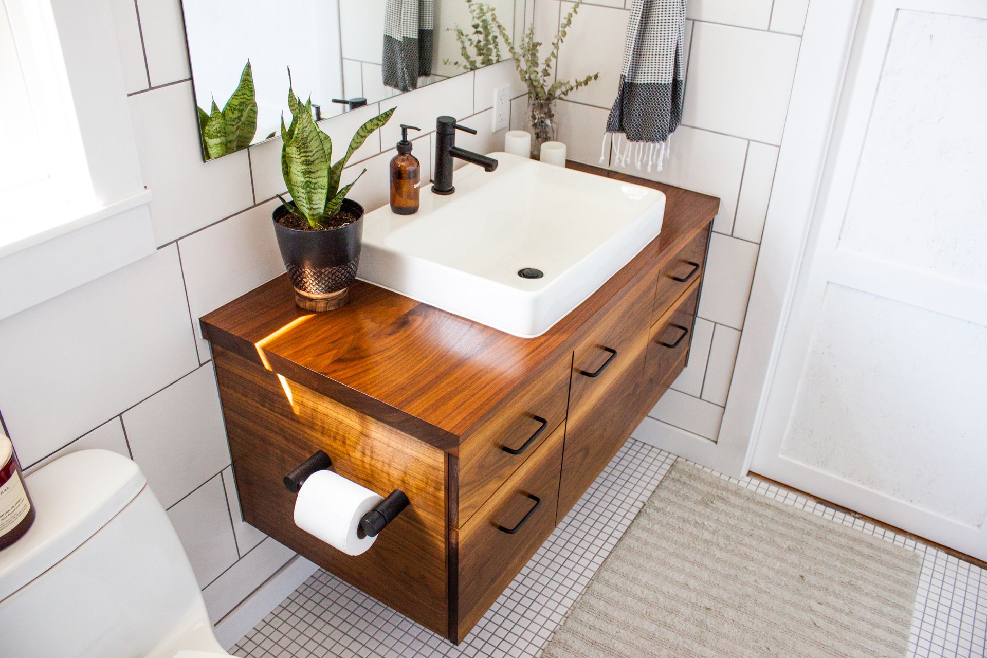 a bathroom with a sink and a plant on the counter
