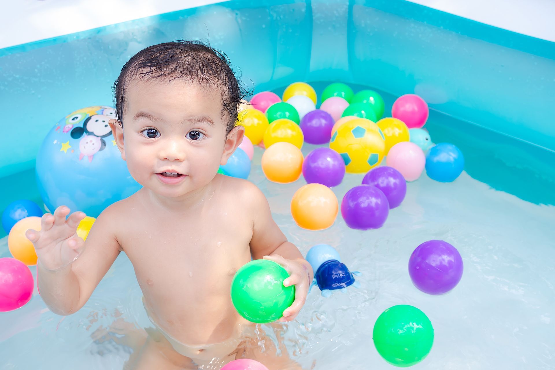 child playing with toys in a swimming pool