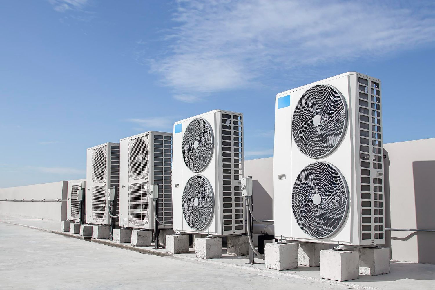 A row of air conditioners sitting on top of a building.