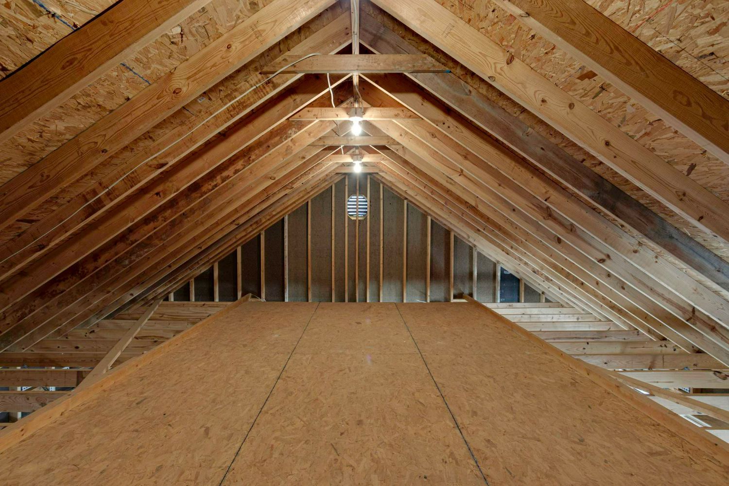 An empty attic with wooden beams and a ceiling